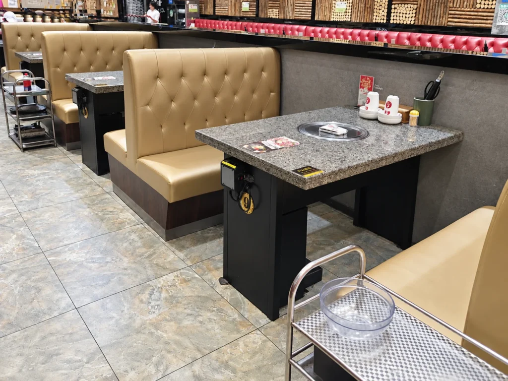 BBQ restaurant booth seating with dark dining tables and upholstered seats.