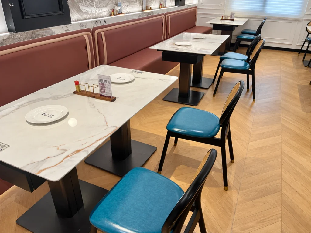Stone-look restaurant dining table with rattan-style dining chairs.